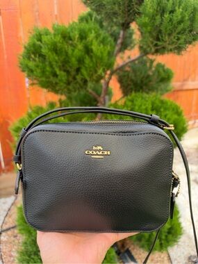 Coach Black Pebbled Leather Crossbody with Gold Logo. BROWSE THROUGH PHOTOS.